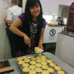 Maria helping to serve egg tarts to guests