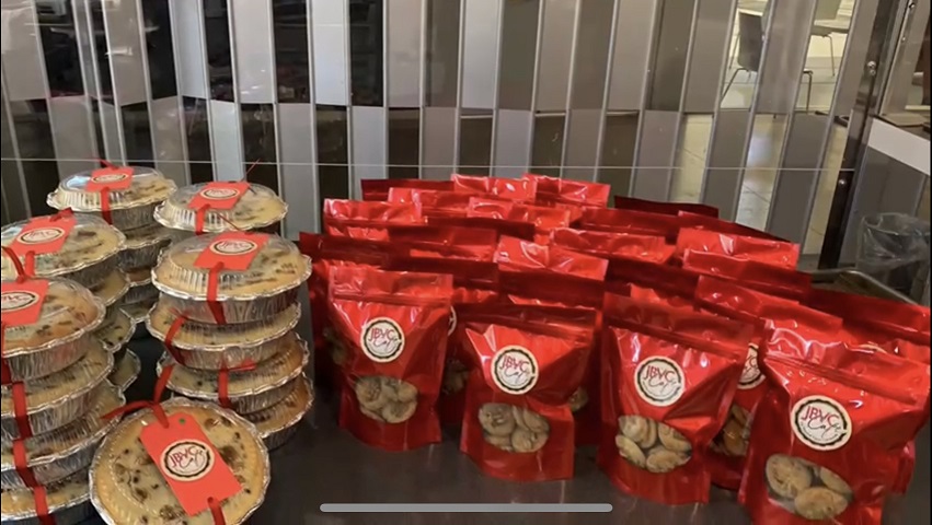Multiple red package of Luna new year cookies next to a stack of around Japanese walnut cake 